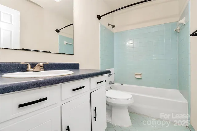 a bathroom with a granite countertop sink a toilet and a mirror