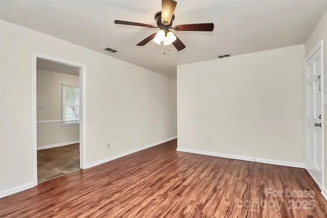 a view of room with hardwood floor and a ceiling fan