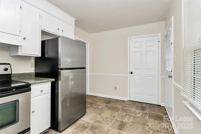 a kitchen with refrigerator and cabinets