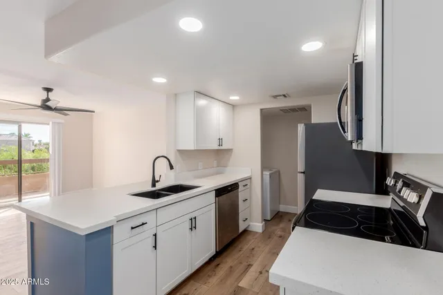 a kitchen with granite countertop a sink stainless steel appliances and cabinets