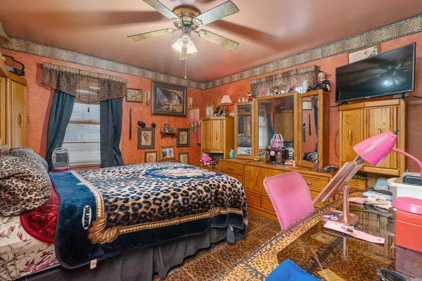 a bedroom with a bed a large window and chandelier