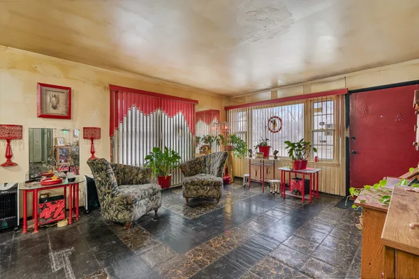 a living room with furniture a flat screen tv and a floor to ceiling window