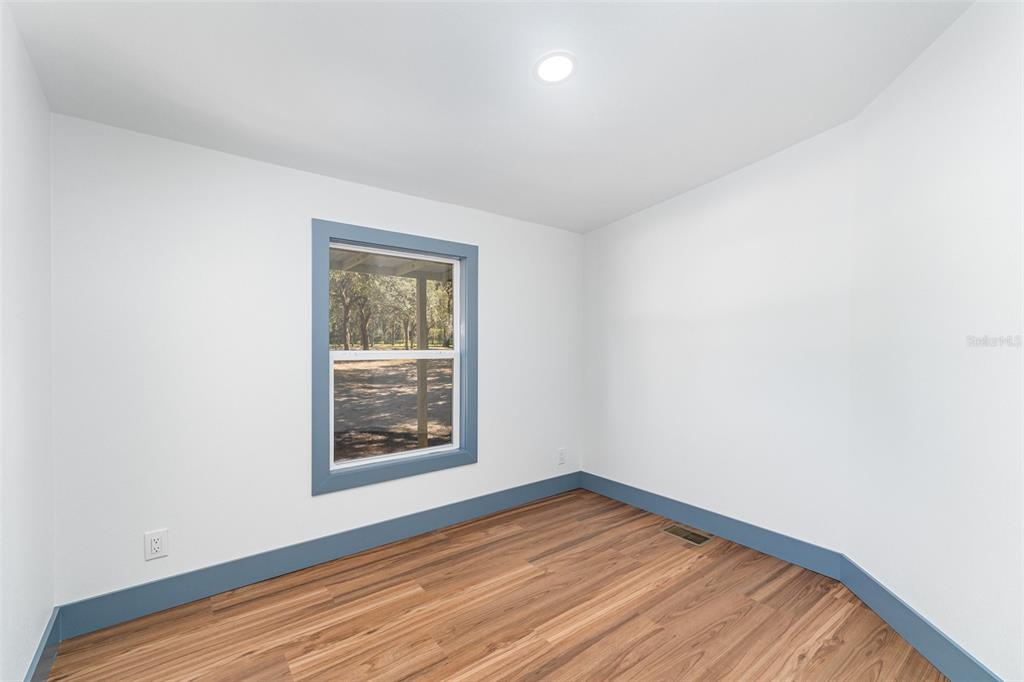 4664 Southwest 181st Court Dunnellon, FL 34432 - Photo 12 of 46 a view of an empty room with window and wooden floor