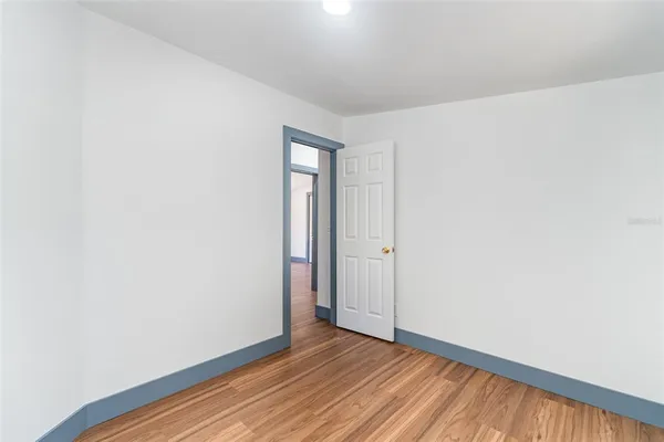 a view of an empty room with wooden floor