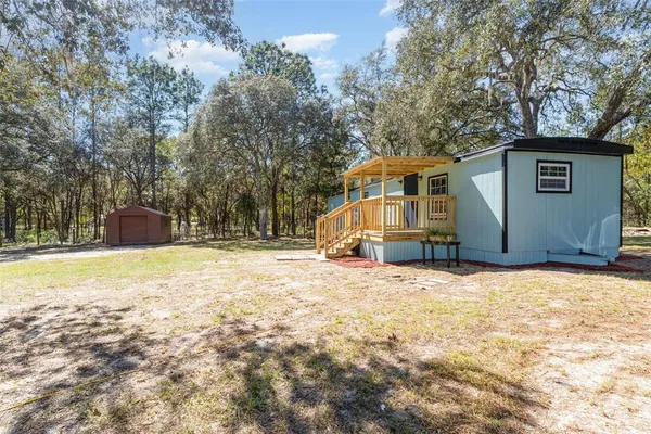 a front view of house with yard and trees in the background
