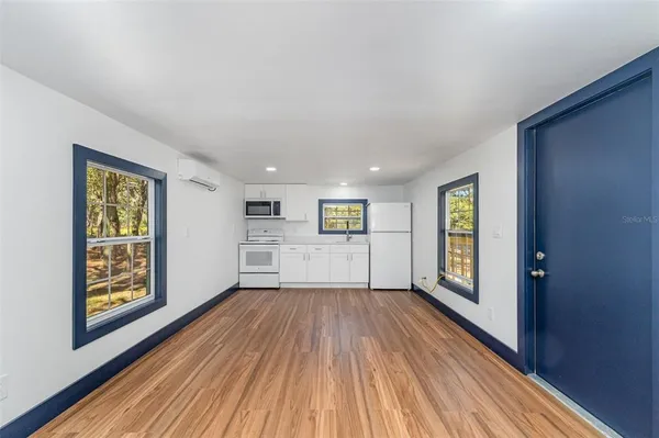 a view of a big room with wooden floor and windows