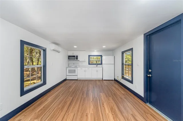 a view of a big room with wooden floor and windows