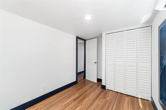 an empty room with wooden floor and white walls