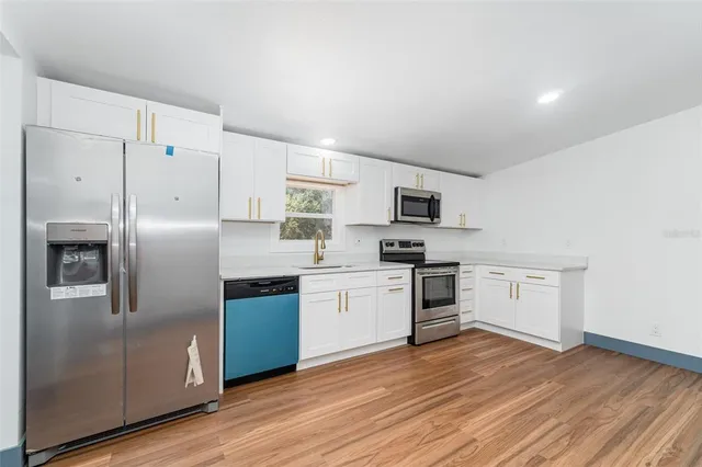 a kitchen with stainless steel appliances a refrigerator sink and stove top oven