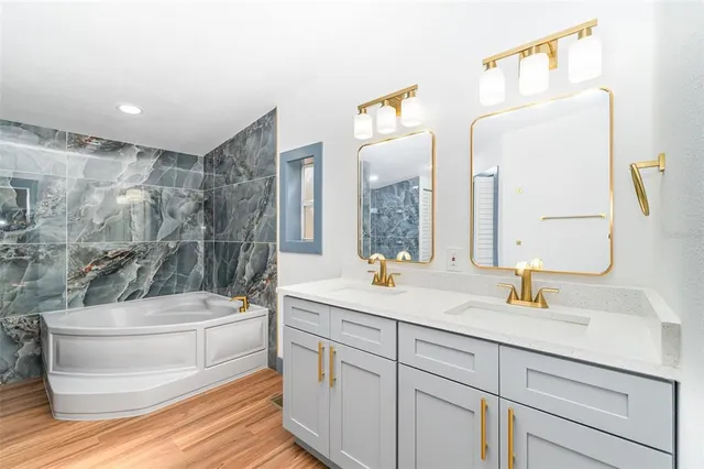 a bathroom with a sink a toilet a mirror and shower