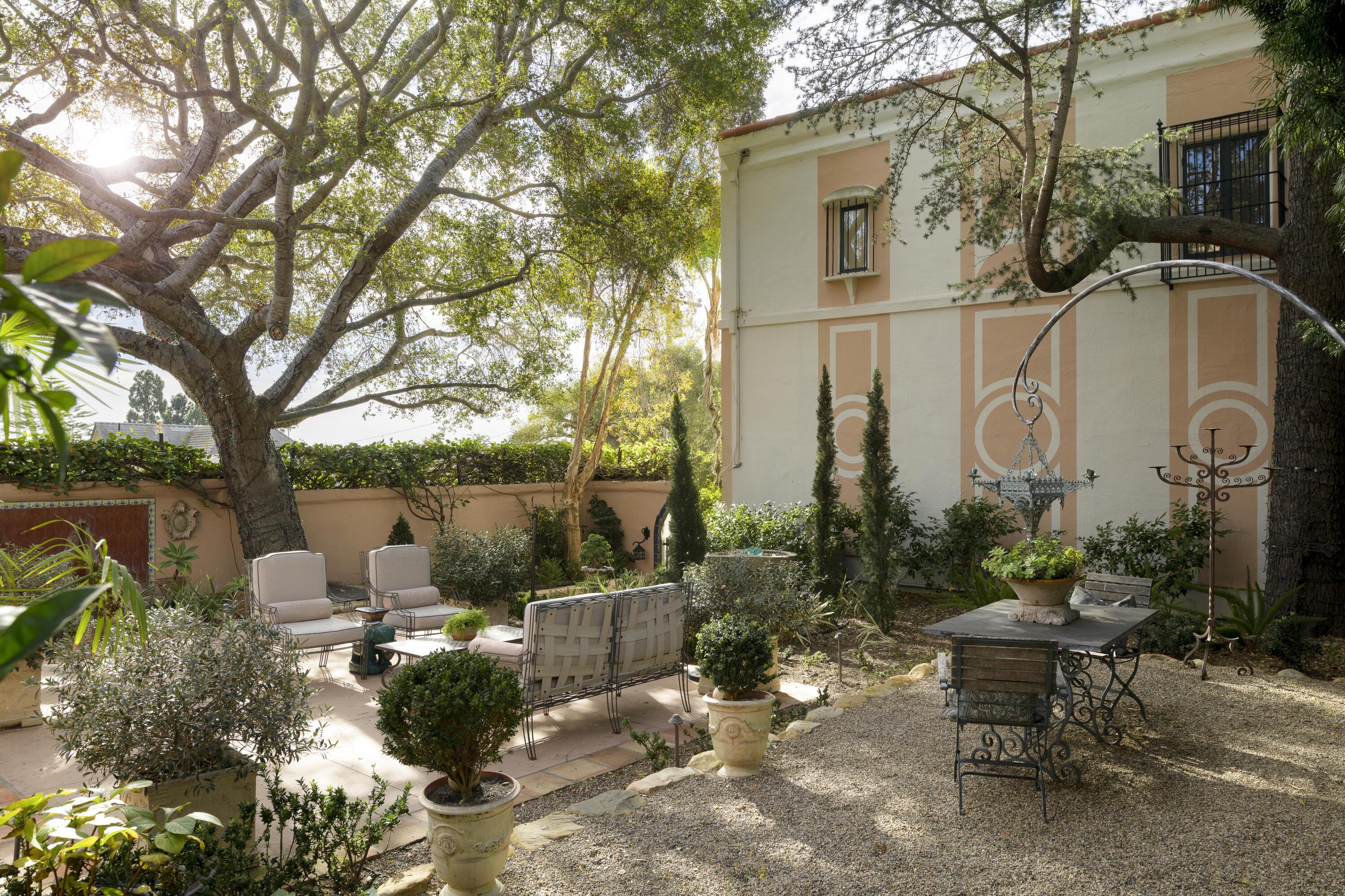 1318 Alta Vista Road Santa Barbara, CA 93103 - Photo 33 of 44 a view of a patio with table and chairs and potted plants with large tree