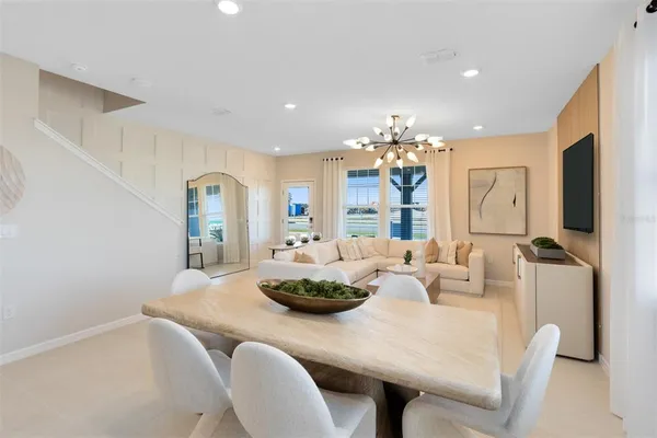 a kitchen with stainless steel appliances kitchen island granite countertop a table chairs and a refrigerator