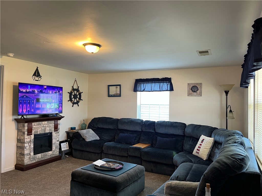 4972 West Fremont Road Port Clinton, OH 43452 - Photo 2 of 29 Living room featuring a wealth of natural light, a fireplace, and dark carpet