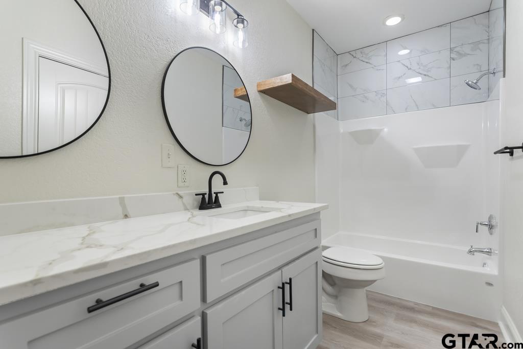 1704 East Houston Street Tyler, TX 75702 - Photo 28 of 33 a bathroom with a sink a toilet and a mirror