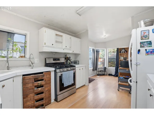 a kitchen with stainless steel appliances granite countertop a stove and white cabinets
