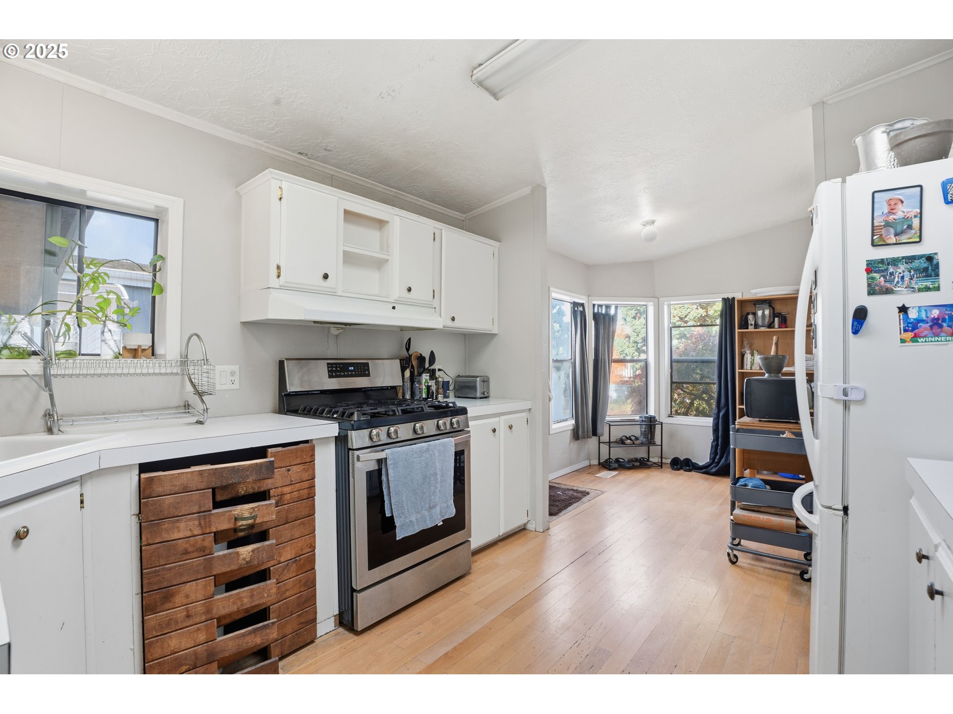 1949 Southeast Palmquist Road, Unit 32 Gresham, OR 97080 - Photo 10 of 31 a kitchen with stainless steel appliances granite countertop a stove and white cabinets