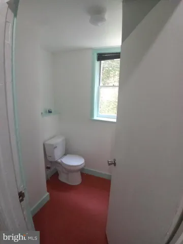 a white toilet sitting next to a window