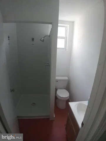 a bathroom with a toilet and a shower