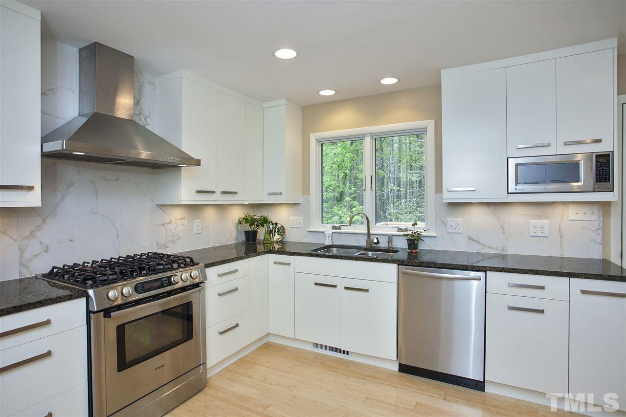 9605 Rock Creek Road Raleigh, NC 27613 - Photo 12 of 25 a kitchen with stainless steel appliances granite countertop a sink stove and cabinets