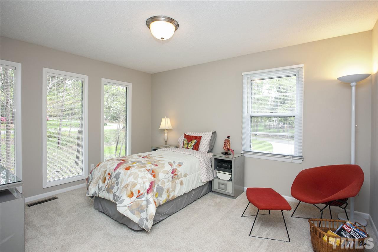 9605 Rock Creek Road Raleigh, NC 27613 - Photo 15 of 25 a bedroom with a bed a dresser and a large window