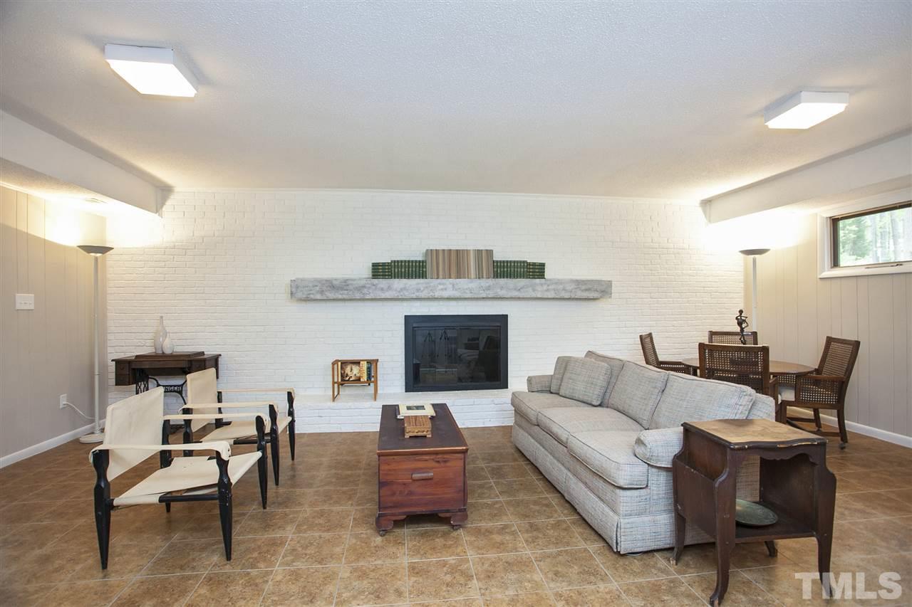 9605 Rock Creek Road Raleigh, NC 27613 - Photo 18 of 25 a living room with furniture and a fireplace