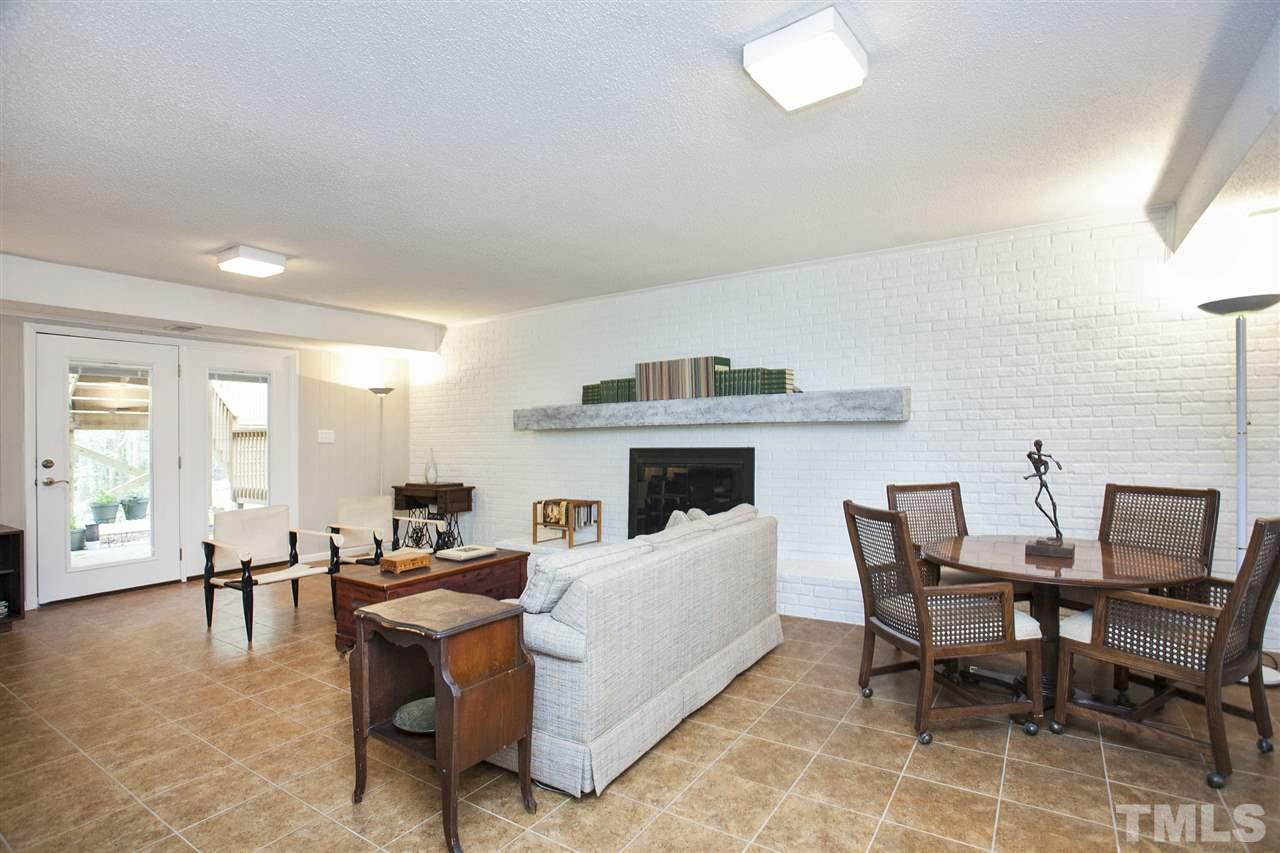 9605 Rock Creek Road Raleigh, NC 27613 - Photo 19 of 25 a living room with furniture a fireplace and a table