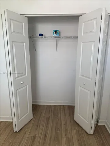 an empty room with wooden floor and closet