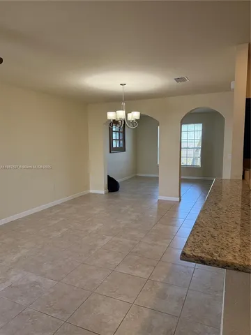 en empty room with window and chandelier