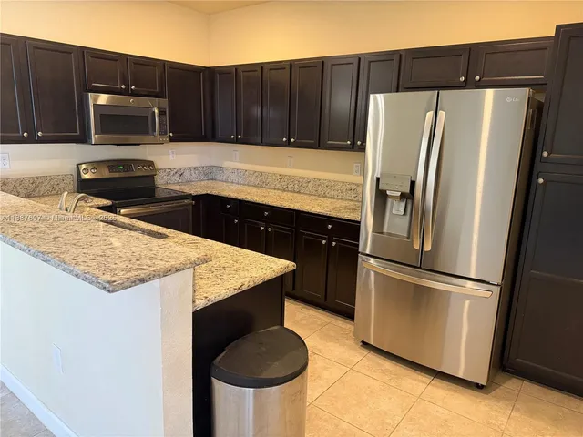 a kitchen with granite countertop stainless steel appliances and wooden cabinets