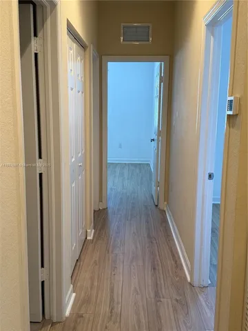 a view of a hallway with wooden floor
