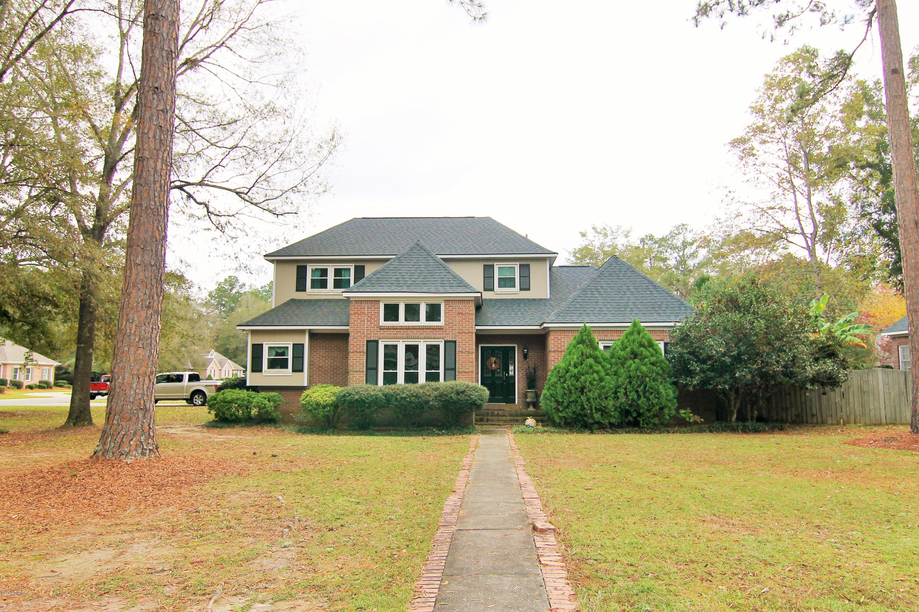 a front view of house with yard and trees around