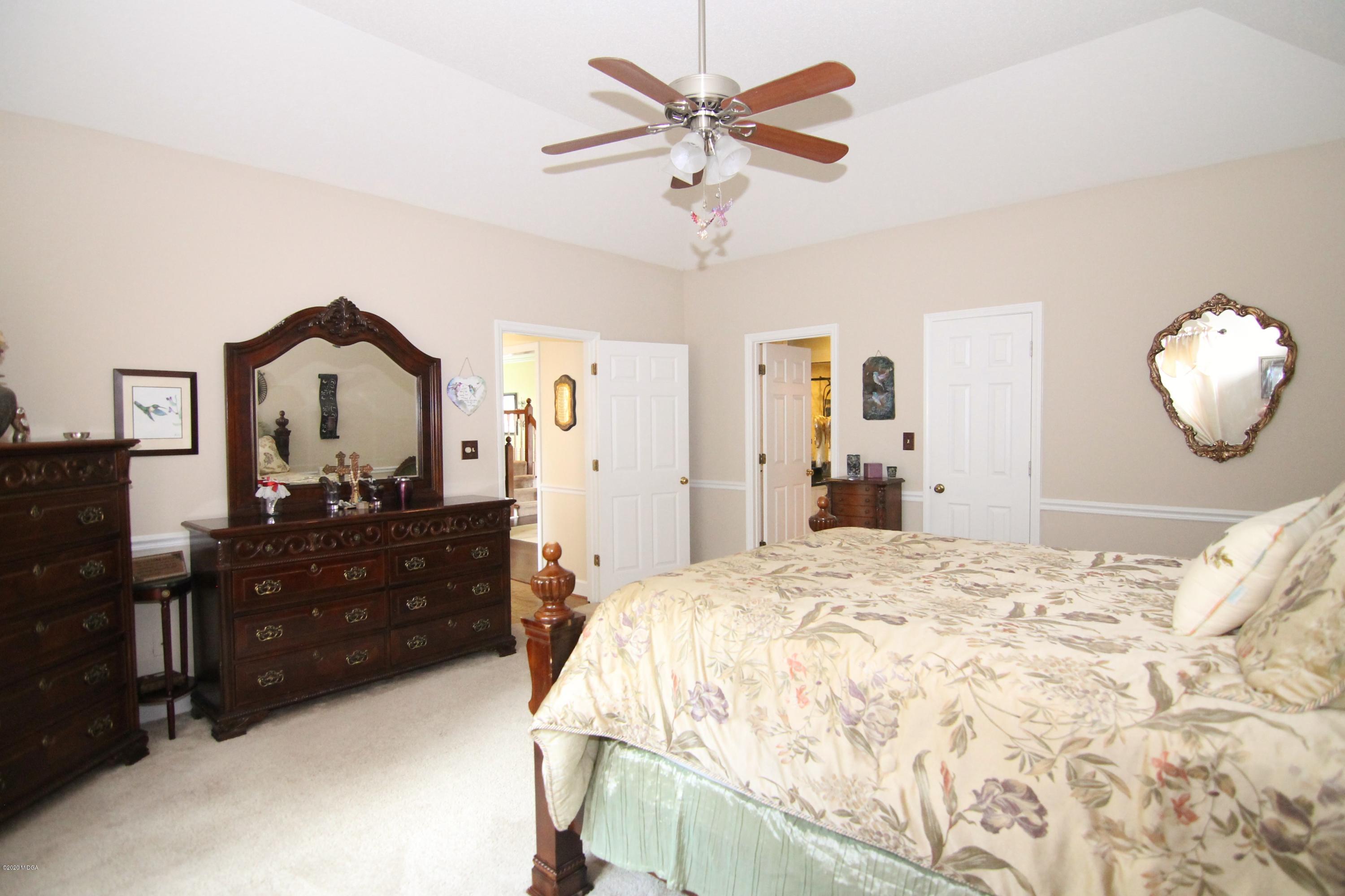 205 Cedar Ridge Drive Perry, GA 31069 - Photo 15 of 39 a bedroom with a bed and a chandelier