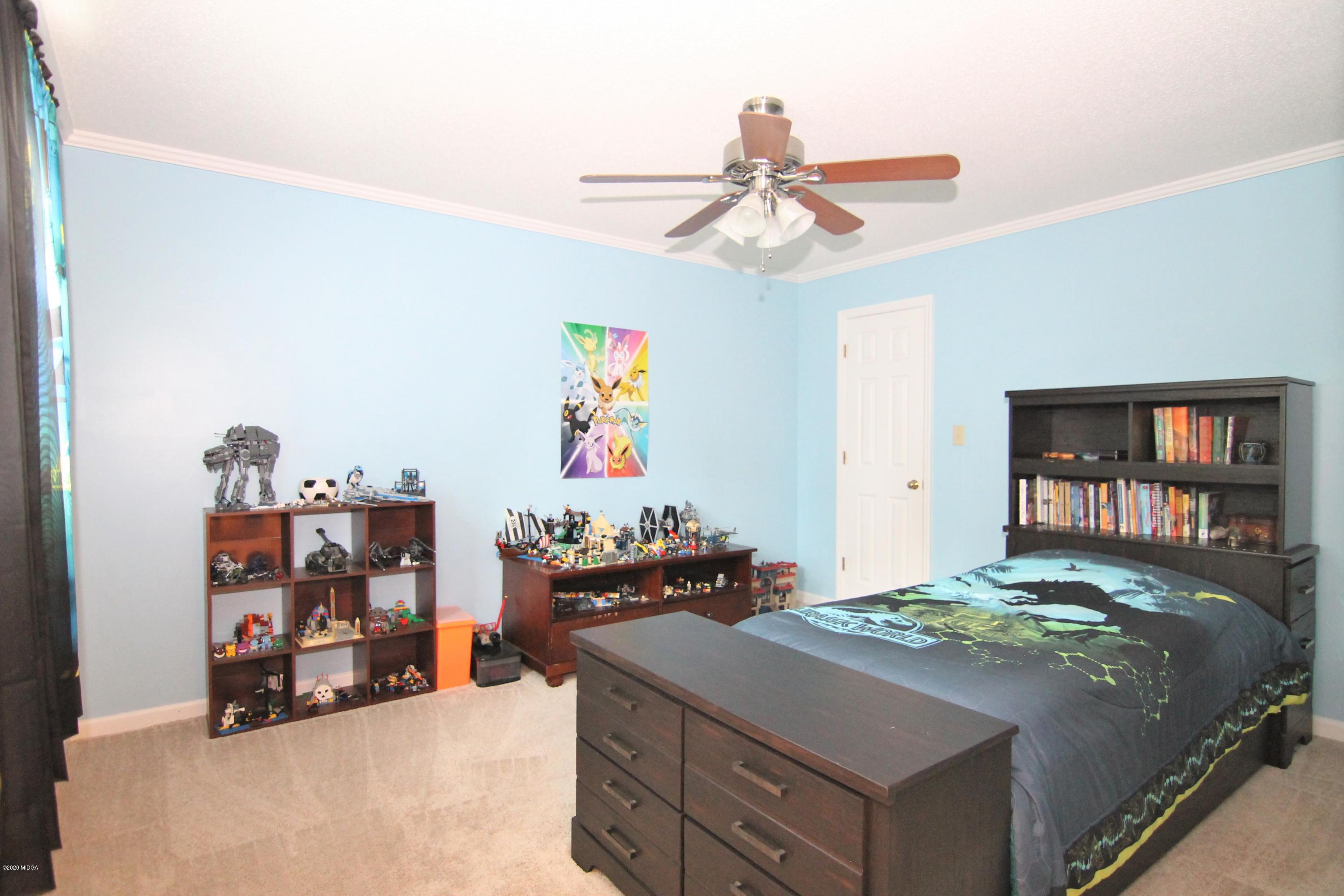 205 Cedar Ridge Drive Perry, GA 31069 - Photo 19 of 39 a bedroom with a bed and a chandelier