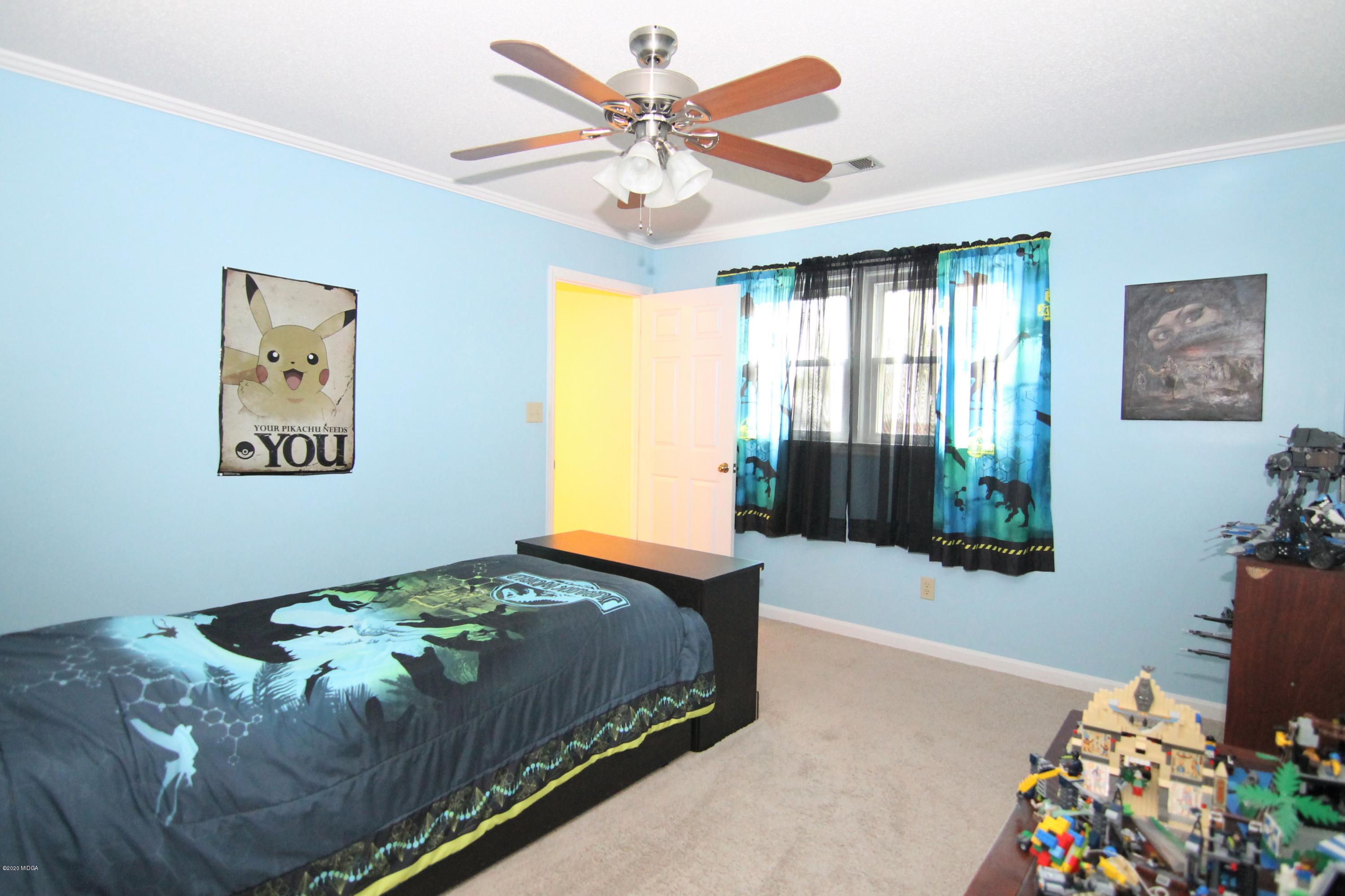 205 Cedar Ridge Drive Perry, GA 31069 - Photo 21 of 39 a bedroom with a bed and a chandelier