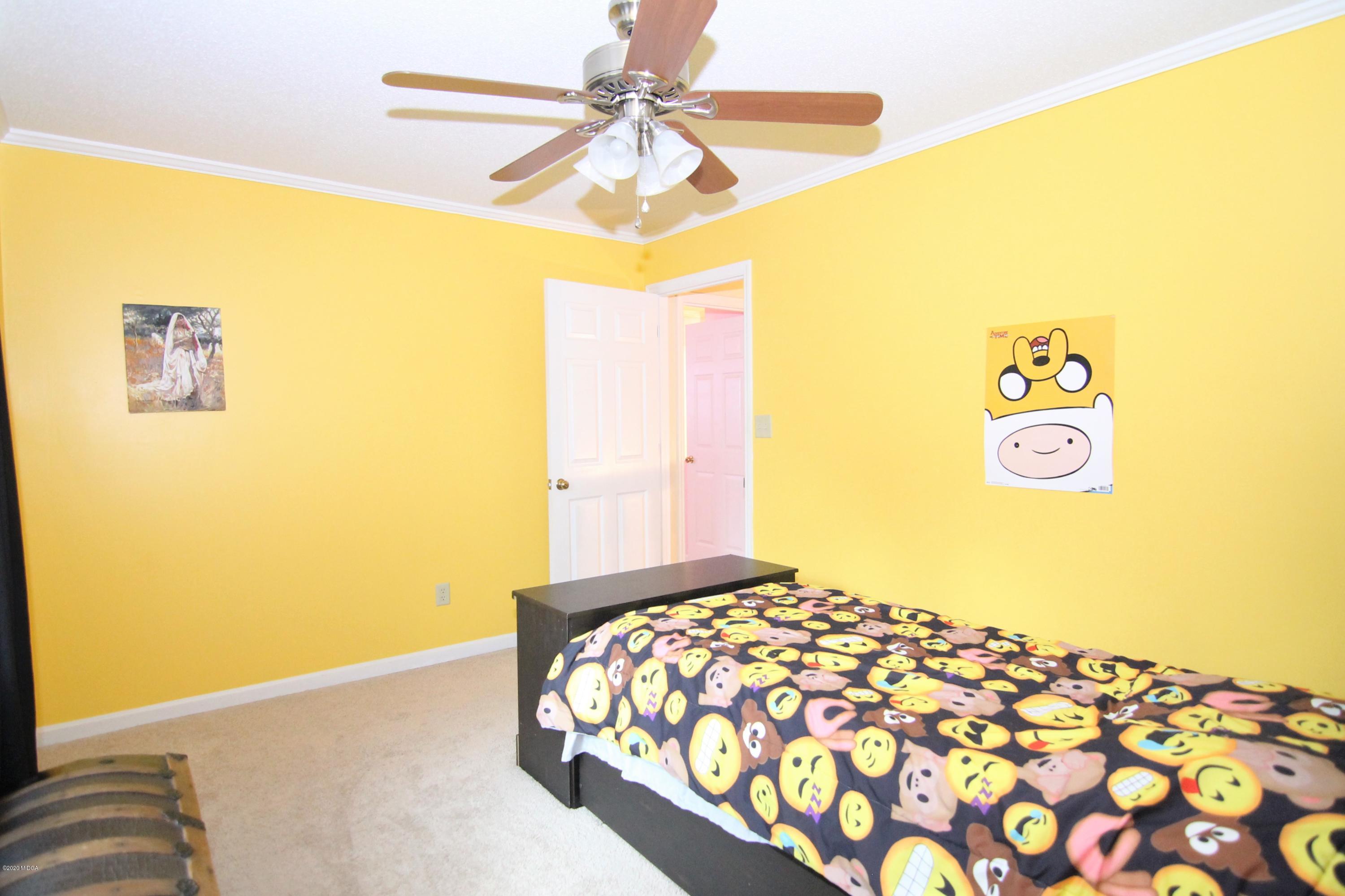 205 Cedar Ridge Drive Perry, GA 31069 - Photo 24 of 39 a bedroom with a bed and a chandelier