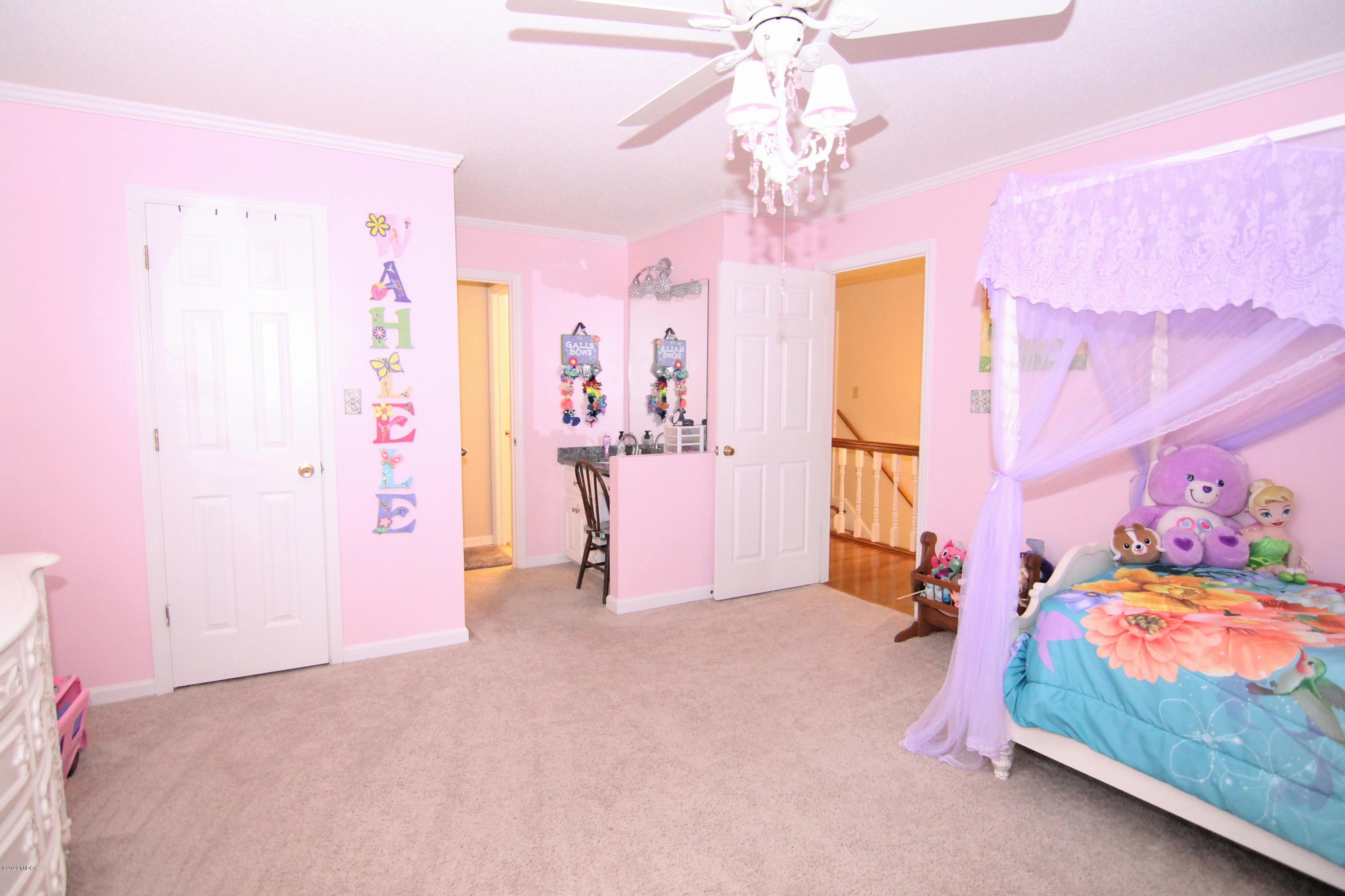205 Cedar Ridge Drive Perry, GA 31069 - Photo 26 of 39 a view of a bedroom with a bed and a chandelier