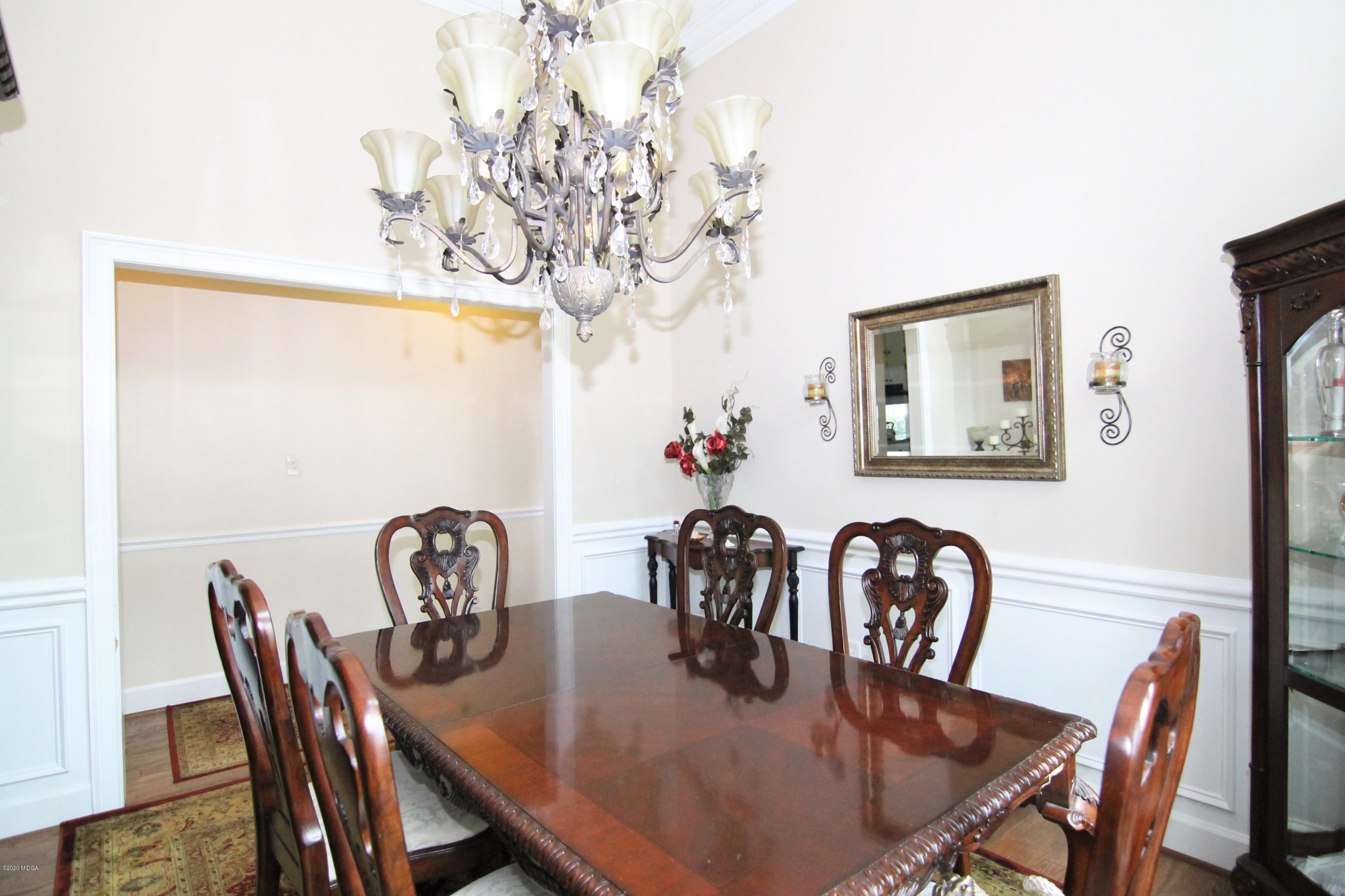 205 Cedar Ridge Drive Perry, GA 31069 - Photo 7 of 39 a view of a dining room with furniture a chandelier and wooden floor