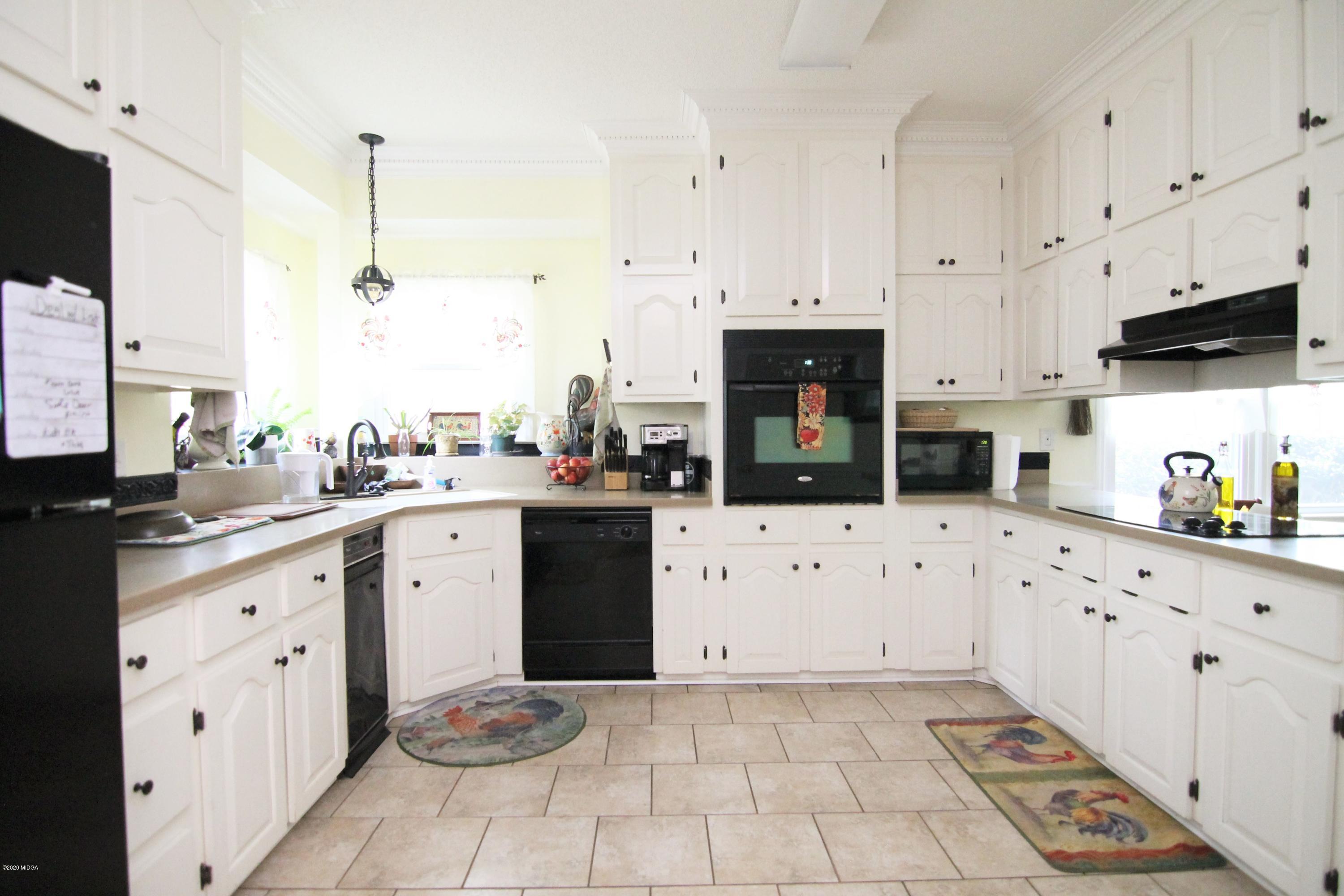 205 Cedar Ridge Drive Perry, GA 31069 - Photo 8 of 39 a kitchen with granite countertop a sink a stove top oven and cabinets