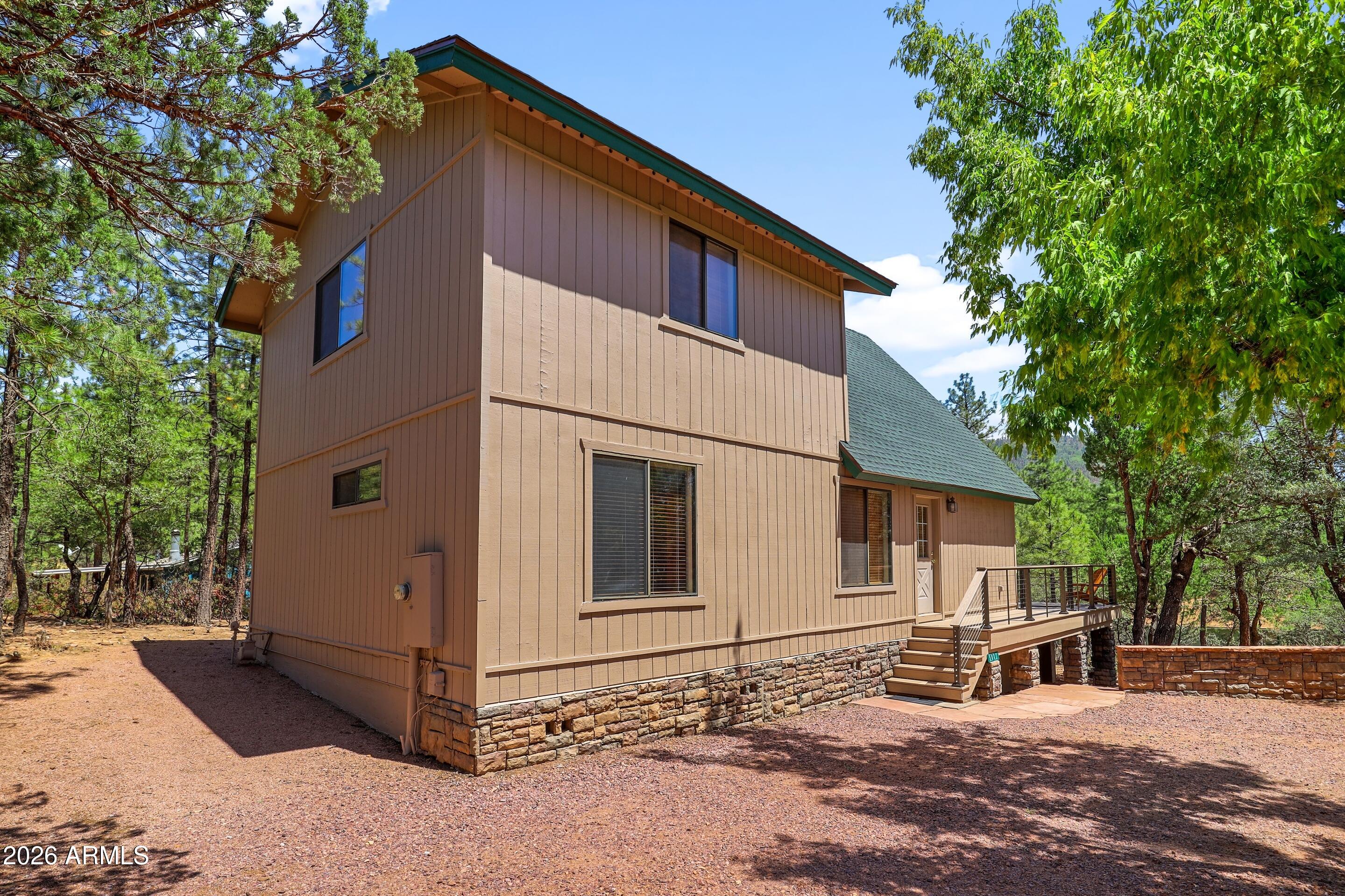 5837 Arroyo Way Pine, AZ 85544 - Photo 26 of 30 a backyard of a house with large trees and outdoor seating