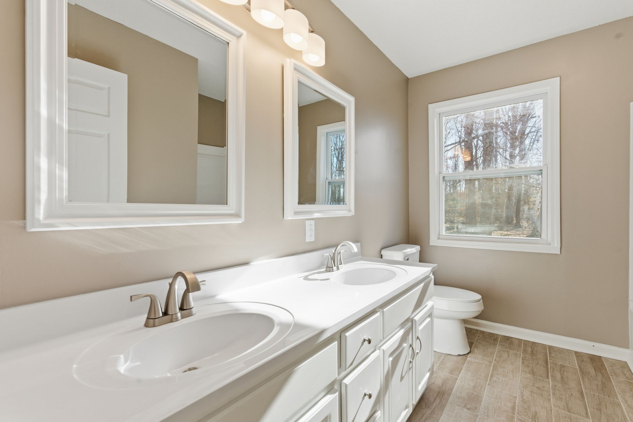 266 Meadows Road Portland, TN 37148 - Photo 6 of 15 a bathroom with a double vanity sink a toilet and a window