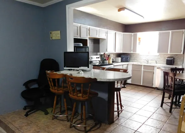 a kitchen with a dining table chairs and microwave