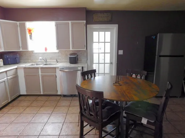 a kitchen with a table chairs and a refrigerator