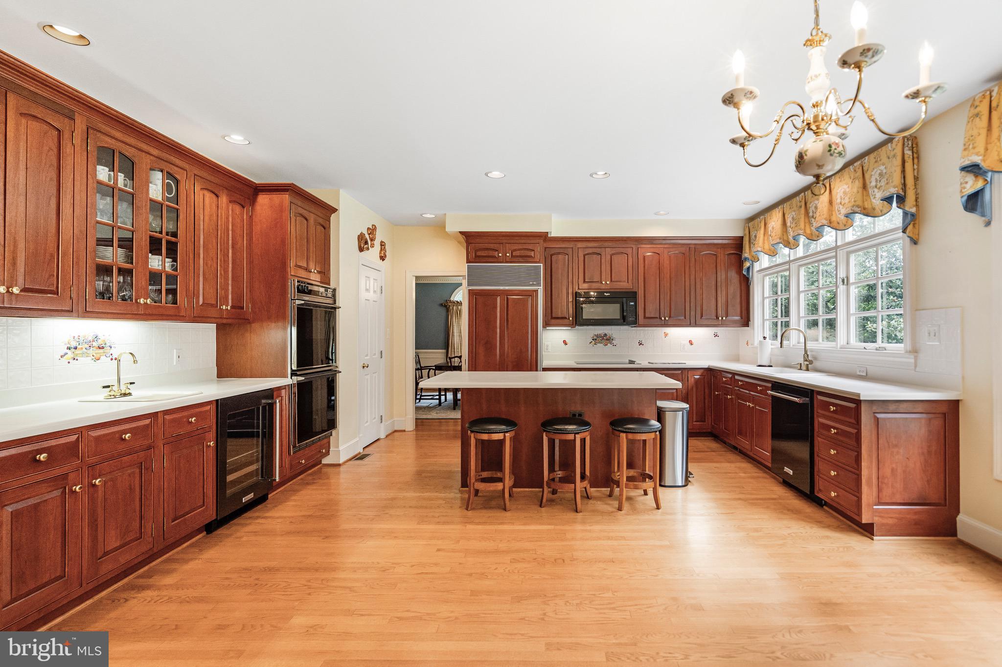 965 St Stephens Church Road Gambrills, MD 21054 - Photo 11 of 43 a kitchen with stainless steel appliances kitchen island granite countertop a table chairs and a refrigerator