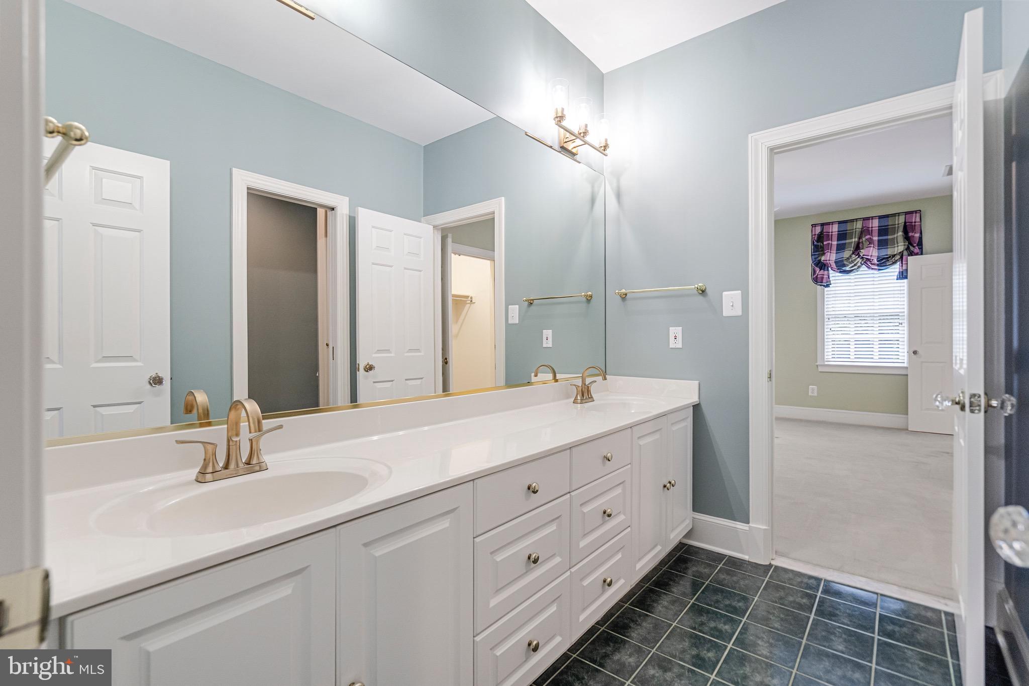 965 St Stephens Church Road Gambrills, MD 21054 - Photo 25 of 43 a bathroom with a double vanity sink a mirror and a bathtub