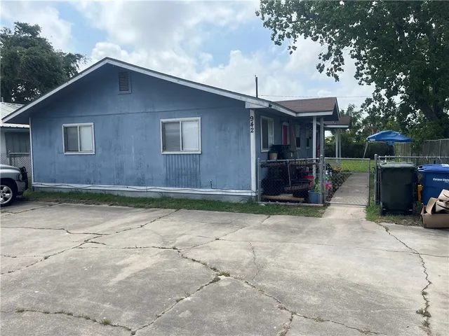 a backyard of a house with barbeque oven table and chairs