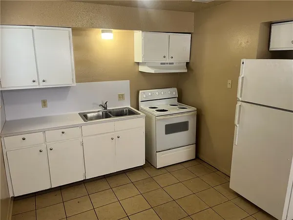 a kitchen with cabinets appliances and a sink