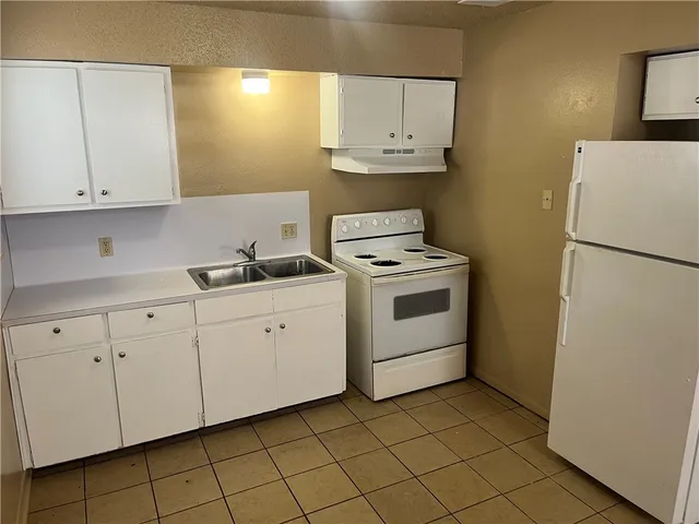 a kitchen with cabinets appliances and a sink