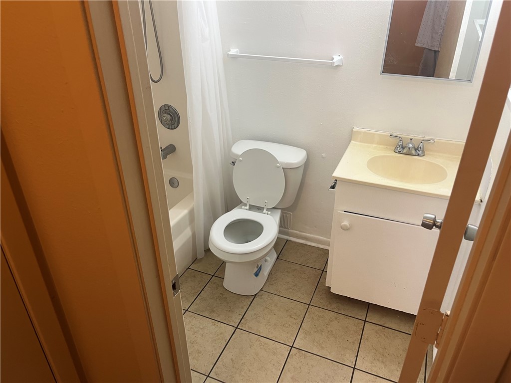 942 Weaver Street, Unit 32 Corpus Christi, TX 78418 - Photo 7 of 12 a white toilet sitting next to a sink and a mirror