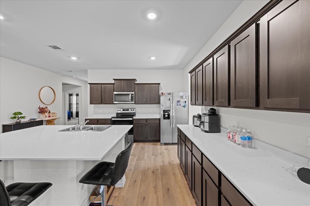 217 Redbarn Lane Caddo Mills, TX 75135 - Photo 6 of 17 a kitchen with kitchen island granite countertop a sink appliances cabinets and a counter top space