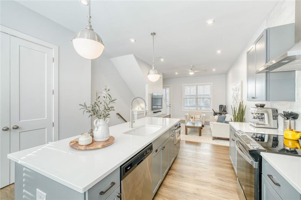4471 Dandelion Lane Atlanta, GA 30342 - Photo 5 of 30 a large kitchen with a counter space a sink appliances and living room view